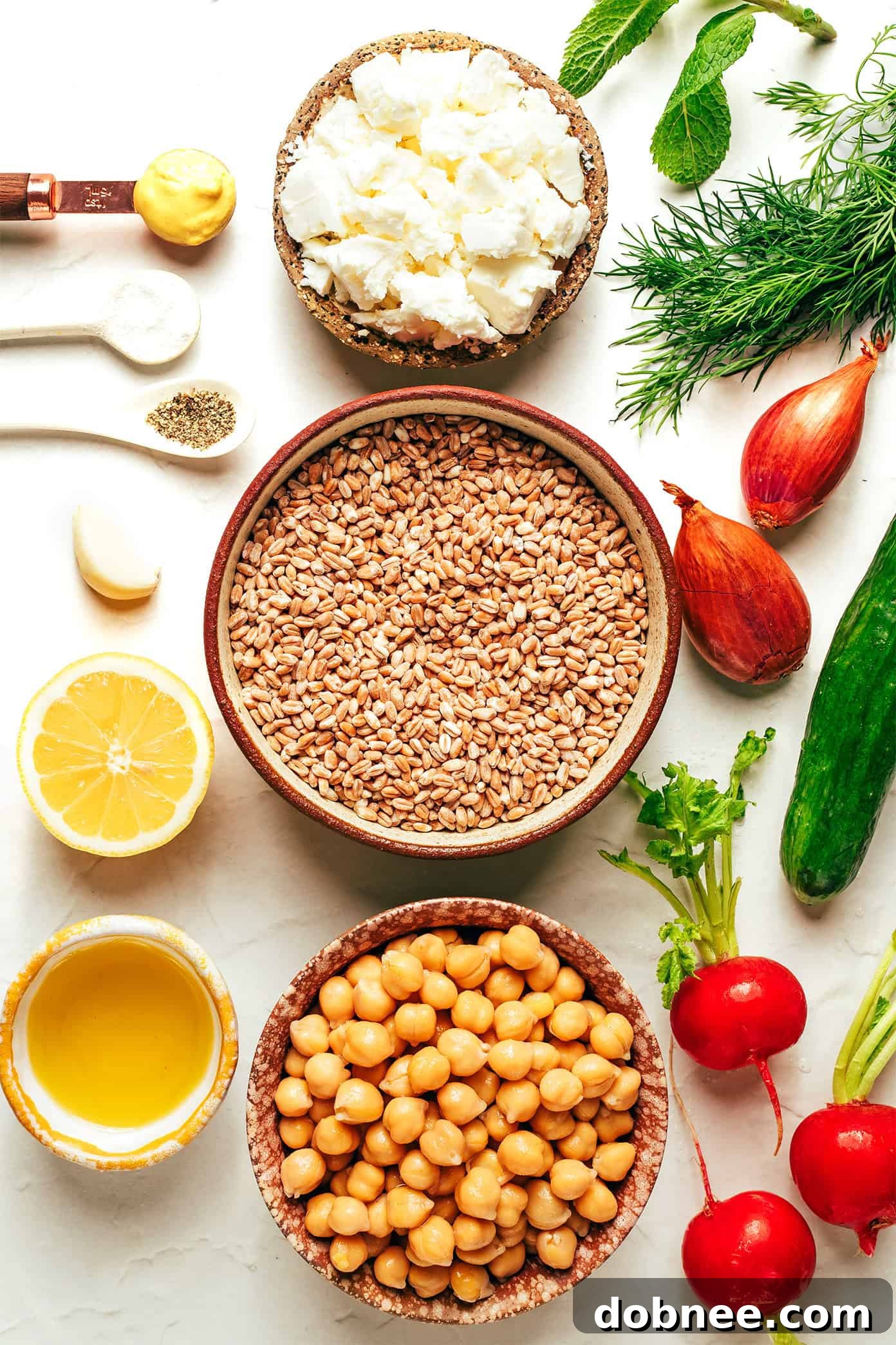 Ingredients for spring farro salad laid out on a wooden board before preparation.