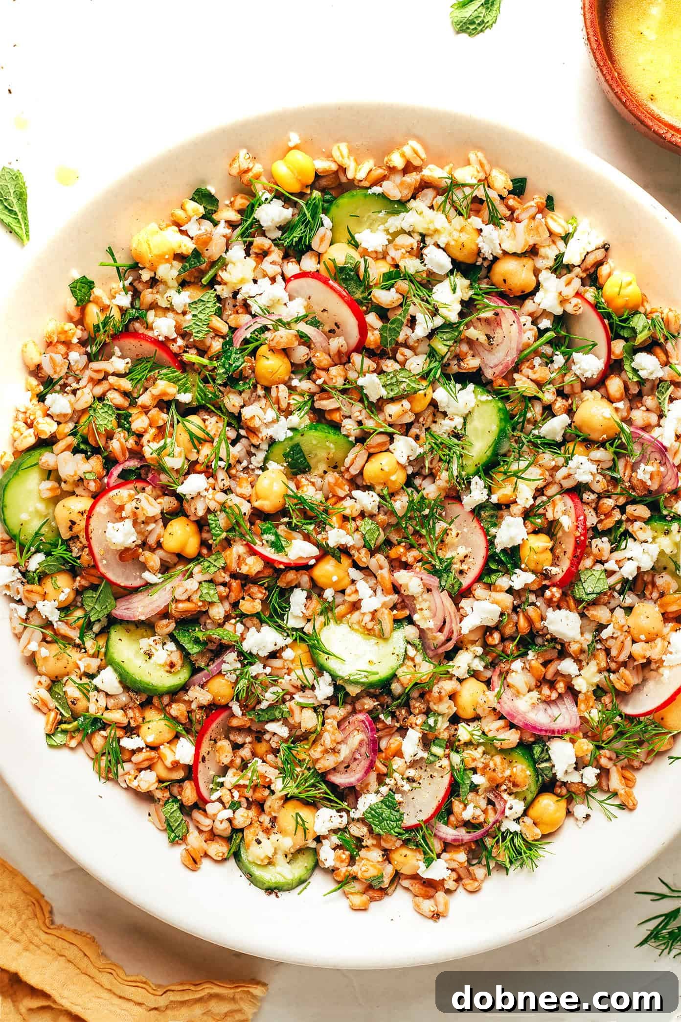 A large serving bowl filled with spring farro salad, ready to be enjoyed.