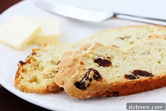Close-up of a rustic, golden-brown Irish Soda Bread loaf with a deep 'X' cut.
