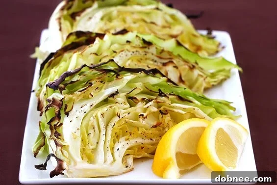 Perfectly roasted green cabbage wedges with golden-brown edges on a baking sheet, ready to be served as a healthy side dish.