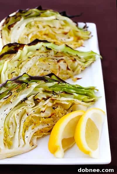 Close-up of a single roasted cabbage wedge, golden brown and perfectly tender, garnished with fresh herbs.
