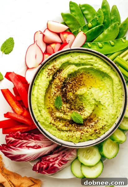 A vibrant bowl of homemade Mint Pea Hummus, ready to be served.