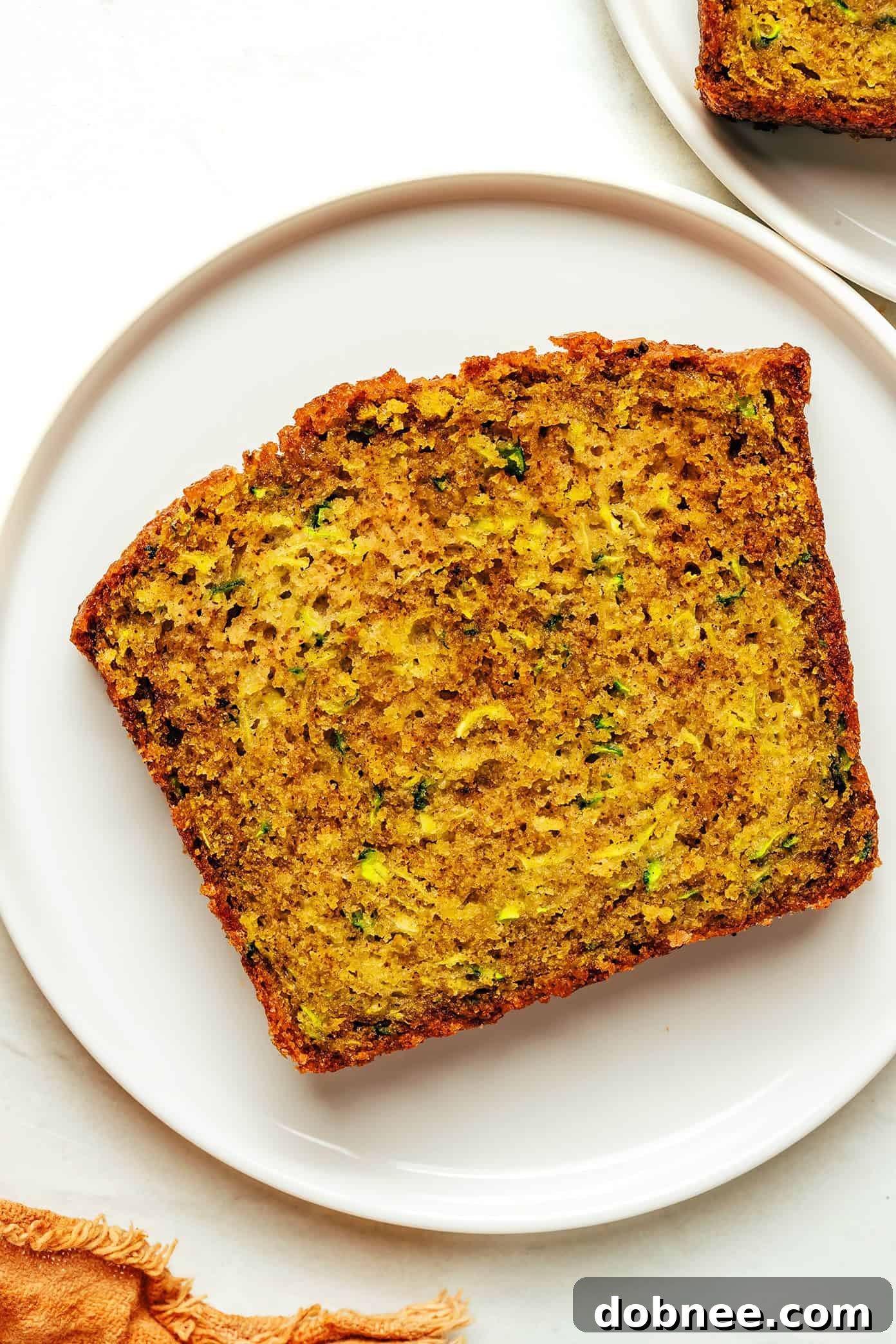 A close-up of a stack of zucchini bread slices, showcasing the crunchy sugar topping.