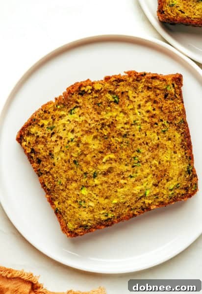 Zucchini bread with a crunchy topping and a knife, ready to be sliced.