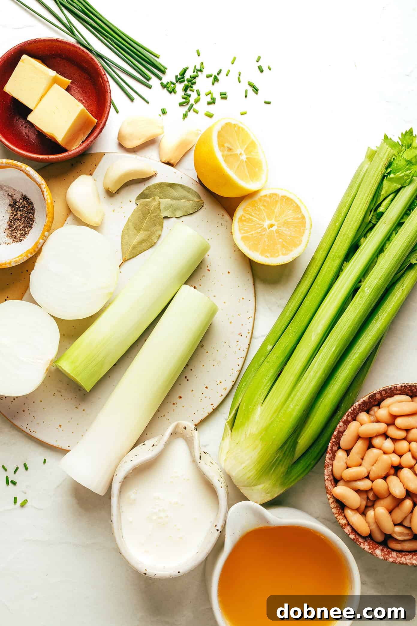 Freshly diced celery, leeks, and onions sautéing in butter in a large pot on the stove.