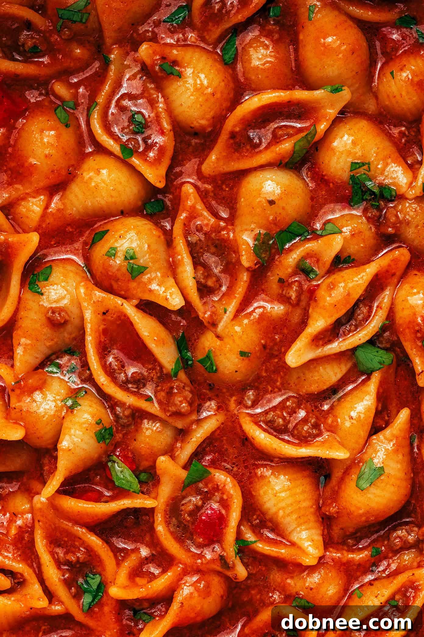 A large pot of One Pot Cheesy Taco Pasta on a stovetop, with a serving spoon, suggesting a fresh, ready-to-eat meal.