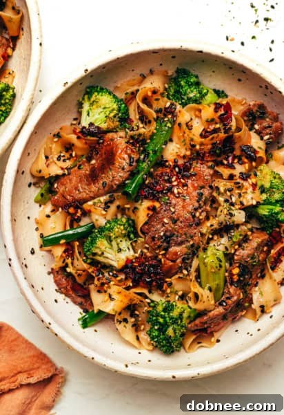 Tender beef and crisp broccoli tossed with chewy noodles in a savory garlic ginger butter sauce, topped with furikake and chili crisp.