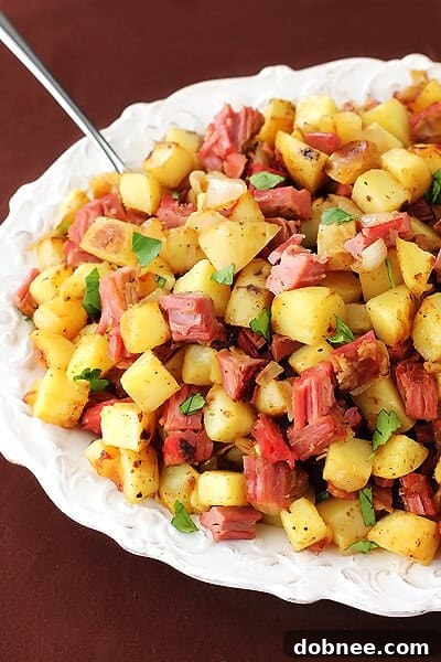 Plated Corned Beef Hash with a perfectly cooked fried egg on top, garnished with herbs.