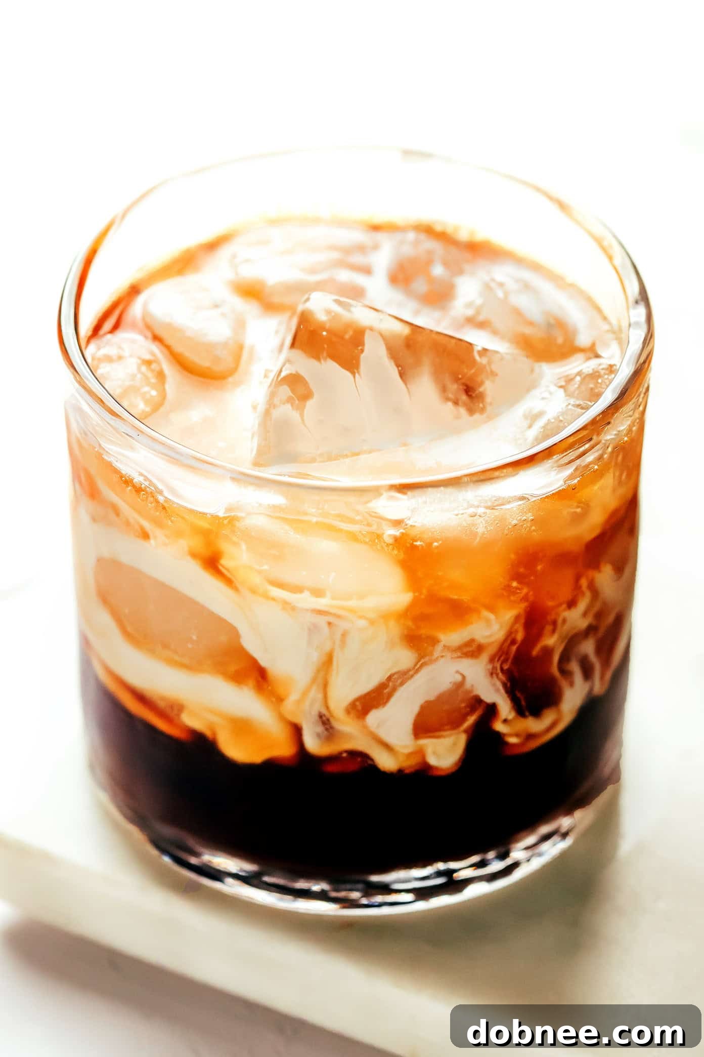 Two White Russian cocktails on a wooden surface