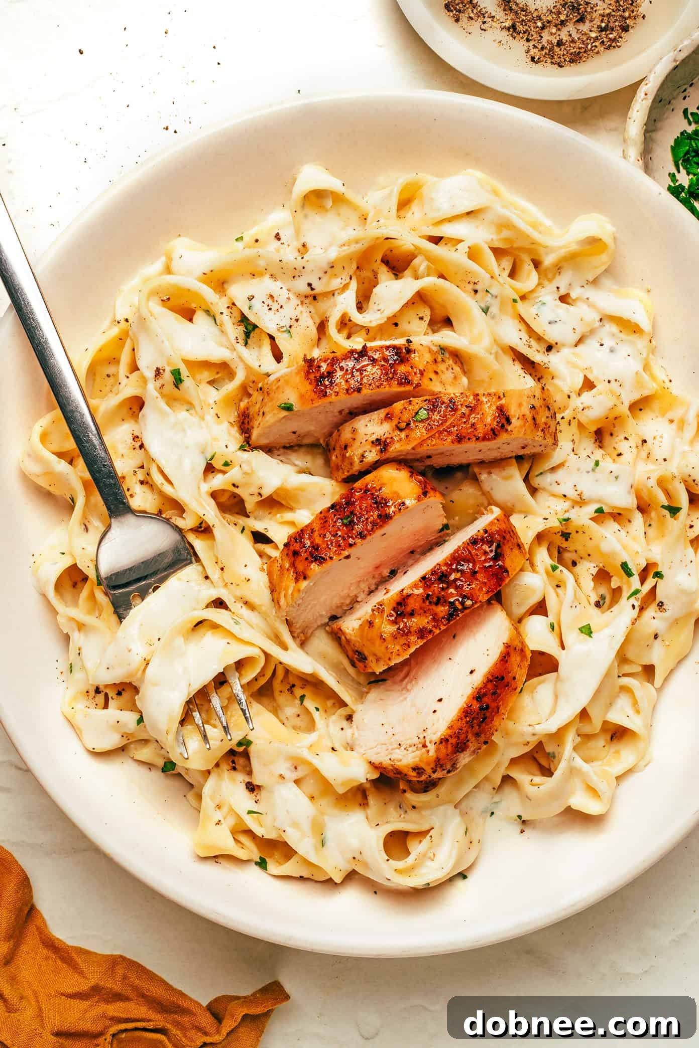 Various creamy pasta dishes in bowls, showcasing different ingredients and serving styles, arranged on a rustic table.