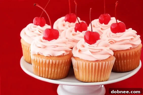 Delicious Cherry Vanilla Cupcakes with vibrant pink frosting, garnished with a maraschino cherry