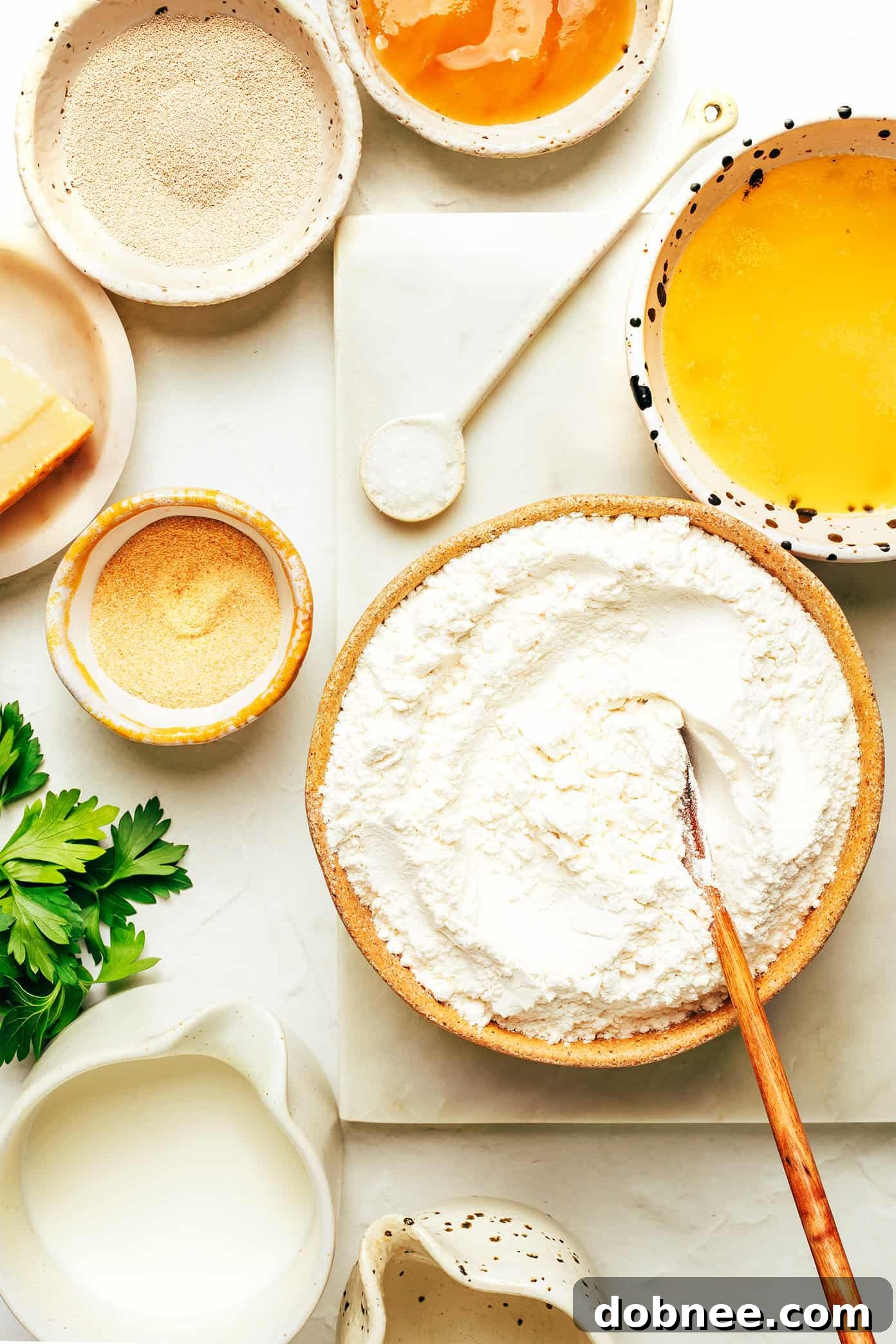 Close-up of a perfectly golden-brown garlic knot, showing its soft texture and glistening garlic butter topping.