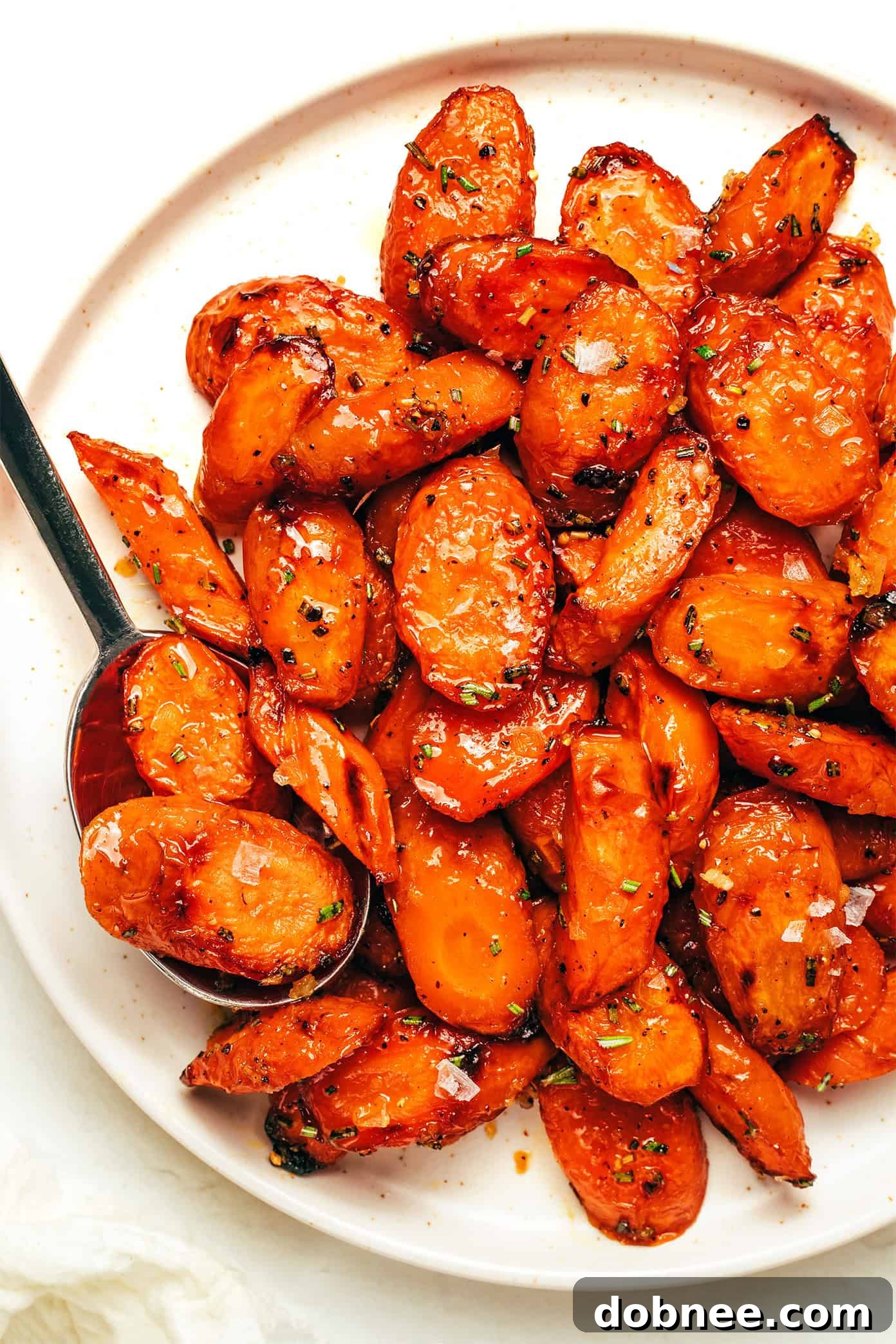 Five small bowls containing various additions for roasted carrots: lemon wedges, grated Parmesan, red pepper flakes, slivered almonds, and chopped parsnips.