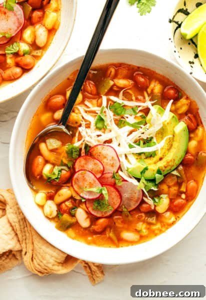 Vegetarian Pozole garnished with fresh herbs and avocado