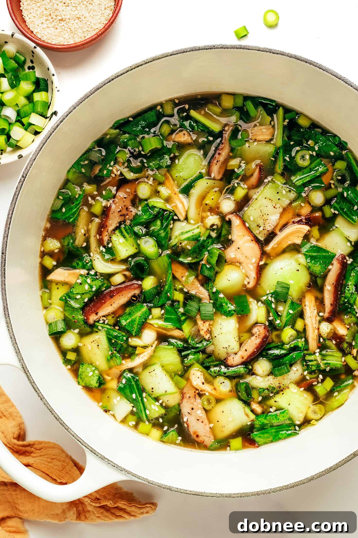 A bowl of ginger scallion chicken soup with a spoon.