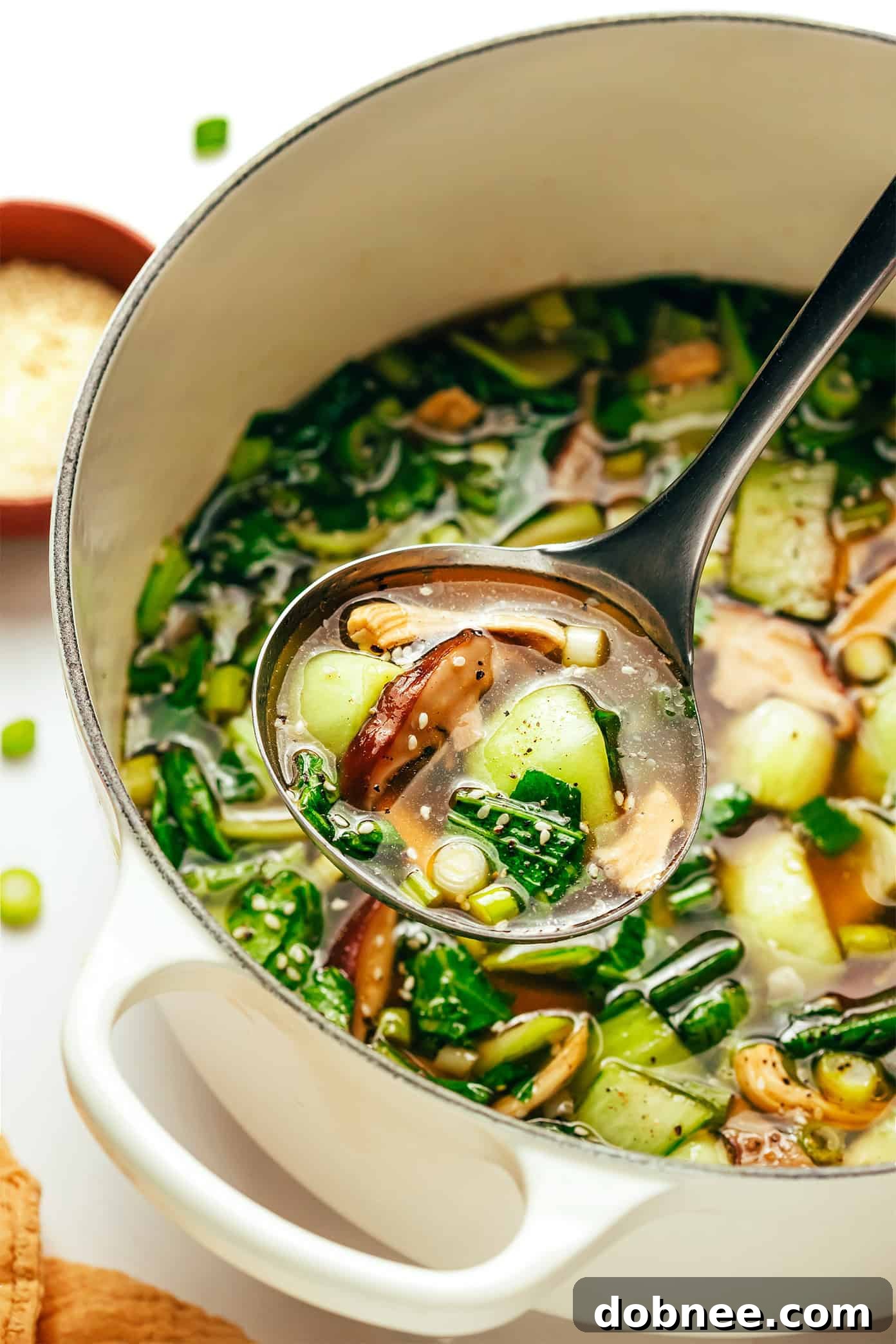 Final presentation of ginger scallion chicken soup in a ceramic bowl.