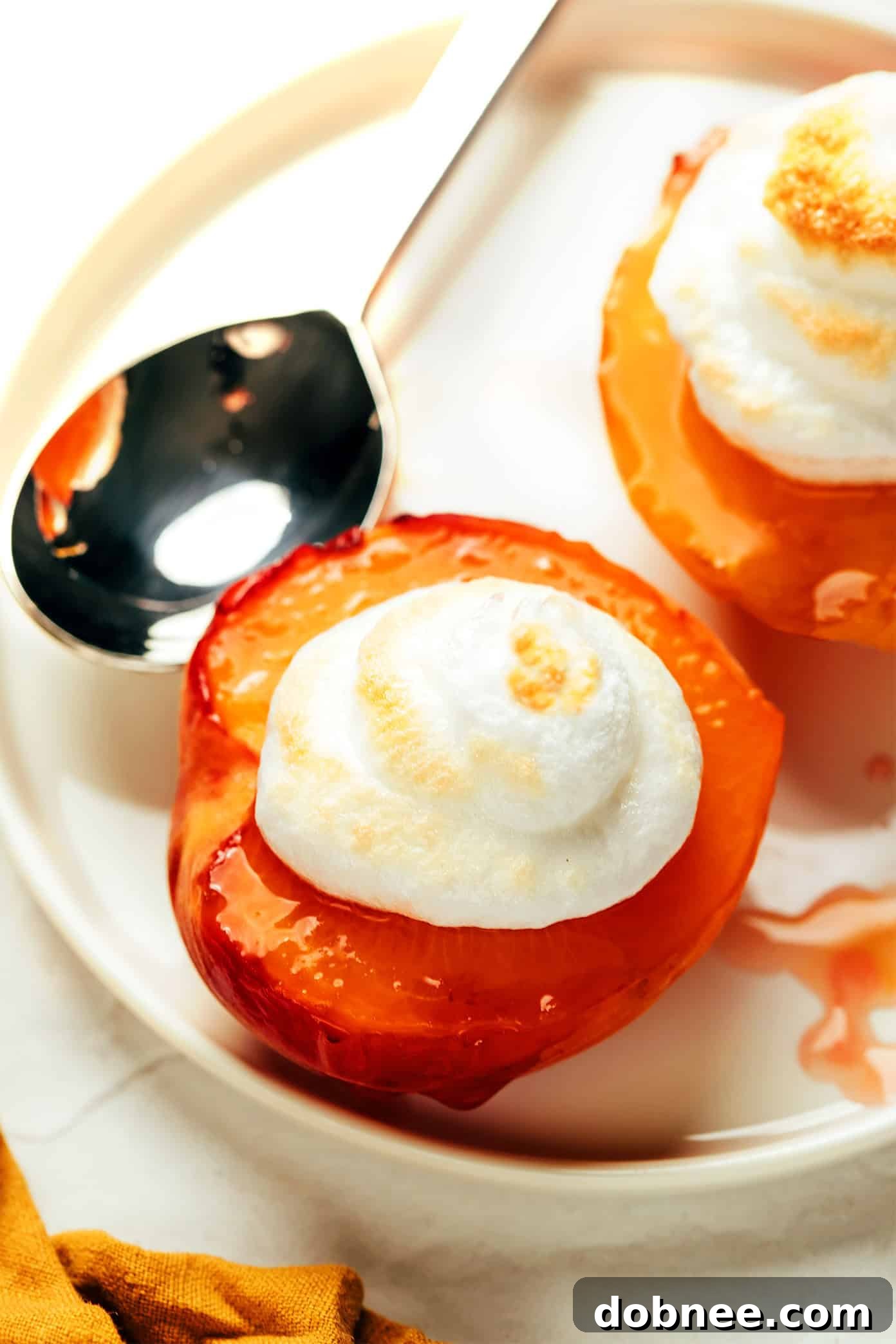 A finished Peaches and Meringue dessert on a white plate, garnished with nuts.