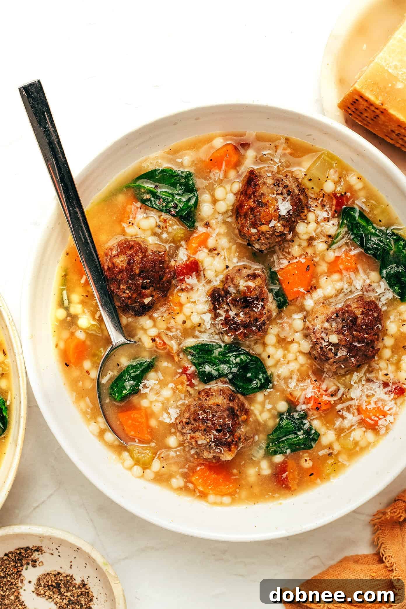 A bowl of Italian Wedding Soup garnished with fresh Parmesan