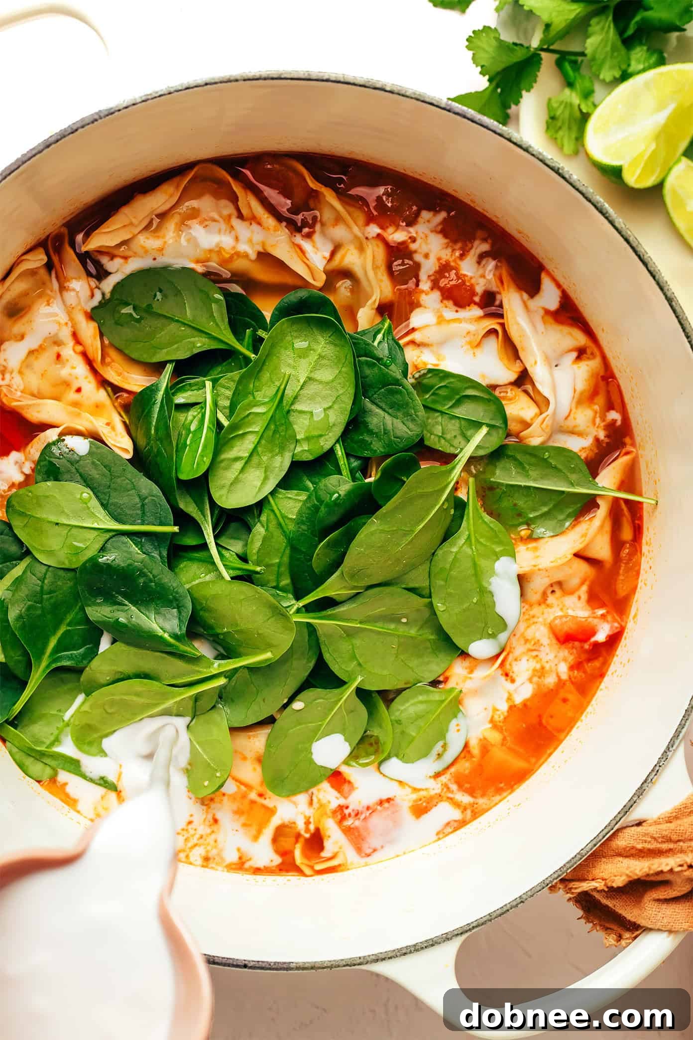 Close-up of the delicious Thai Red Curry Potsticker Soup in a bowl, showcasing the succulent potstickers and colorful vegetables swimming in a creamy broth.