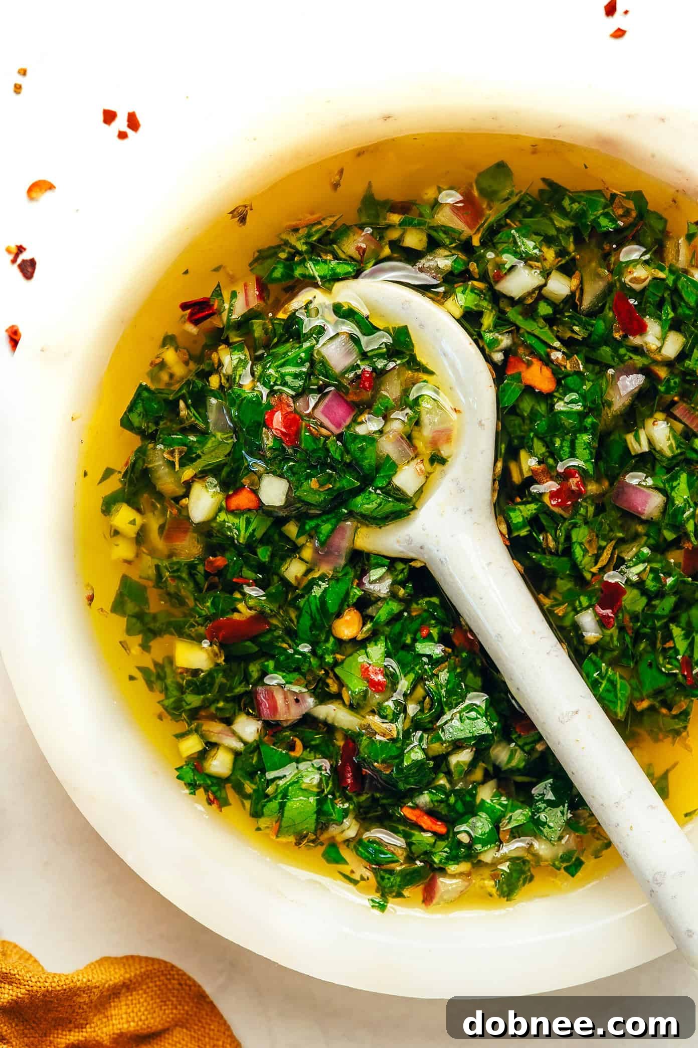 Various dishes that can be served with chimichurri sauce, including grilled chicken and vegetables.