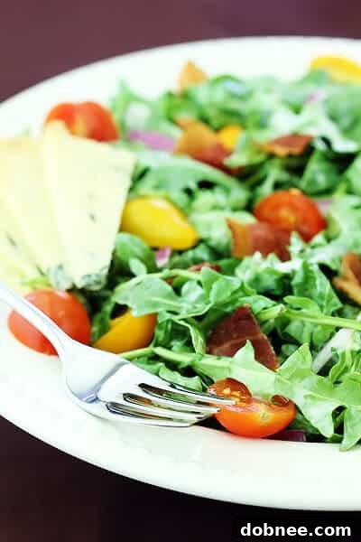 A close-up view of the delicious Arugula Salad with Bacon, Tomatoes, and Buttermilk Dressing, showcasing the fresh ingredients and creamy texture.