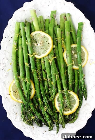 Close-up of vibrant Lemon Pepper Asparagus on a baking sheet, ready to be served