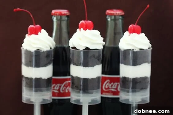 Delicious Coke Float Push-Up Pops layered with Coca-Cola chocolate cake, homemade whipped cream, and a cherry on top, ready for a summer party.