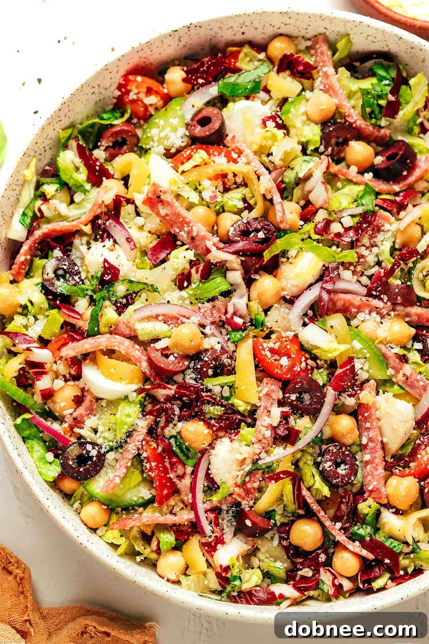 Close-up of Italian chopped salad with salami, chickpeas, and fresh herbs