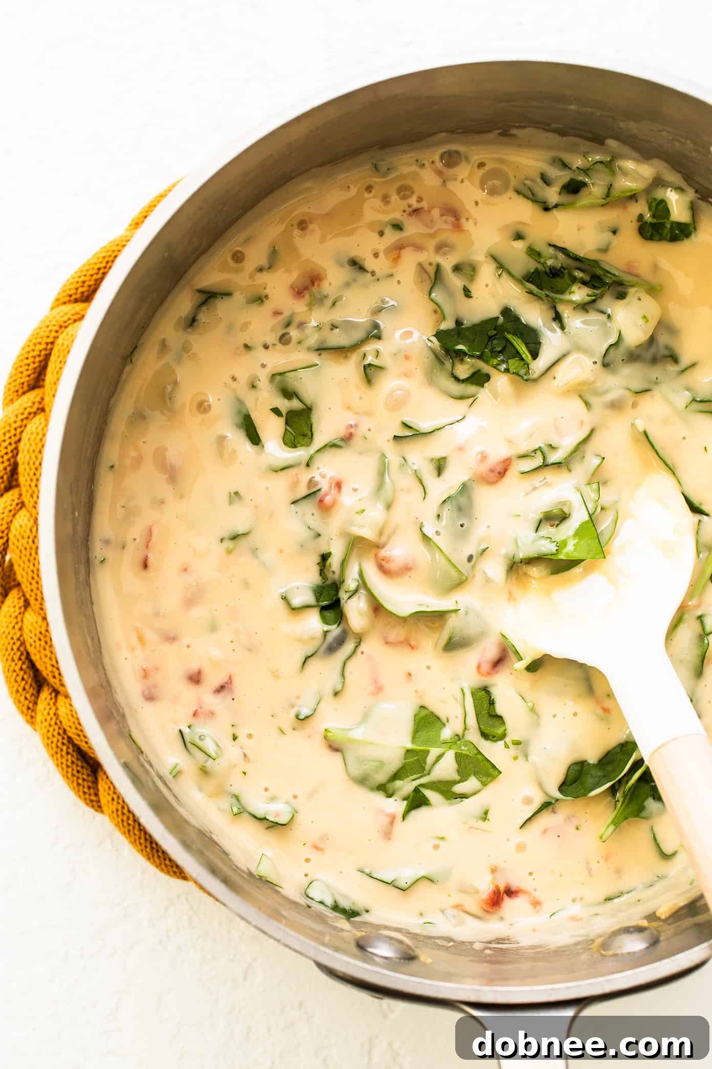 Queso Blanco simmering gently in a saucepan, showcasing its creamy, bubbling texture and ready-to-serve warmth.