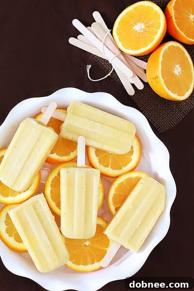 A hand holding a Pineapple Orange Banana Popsicle