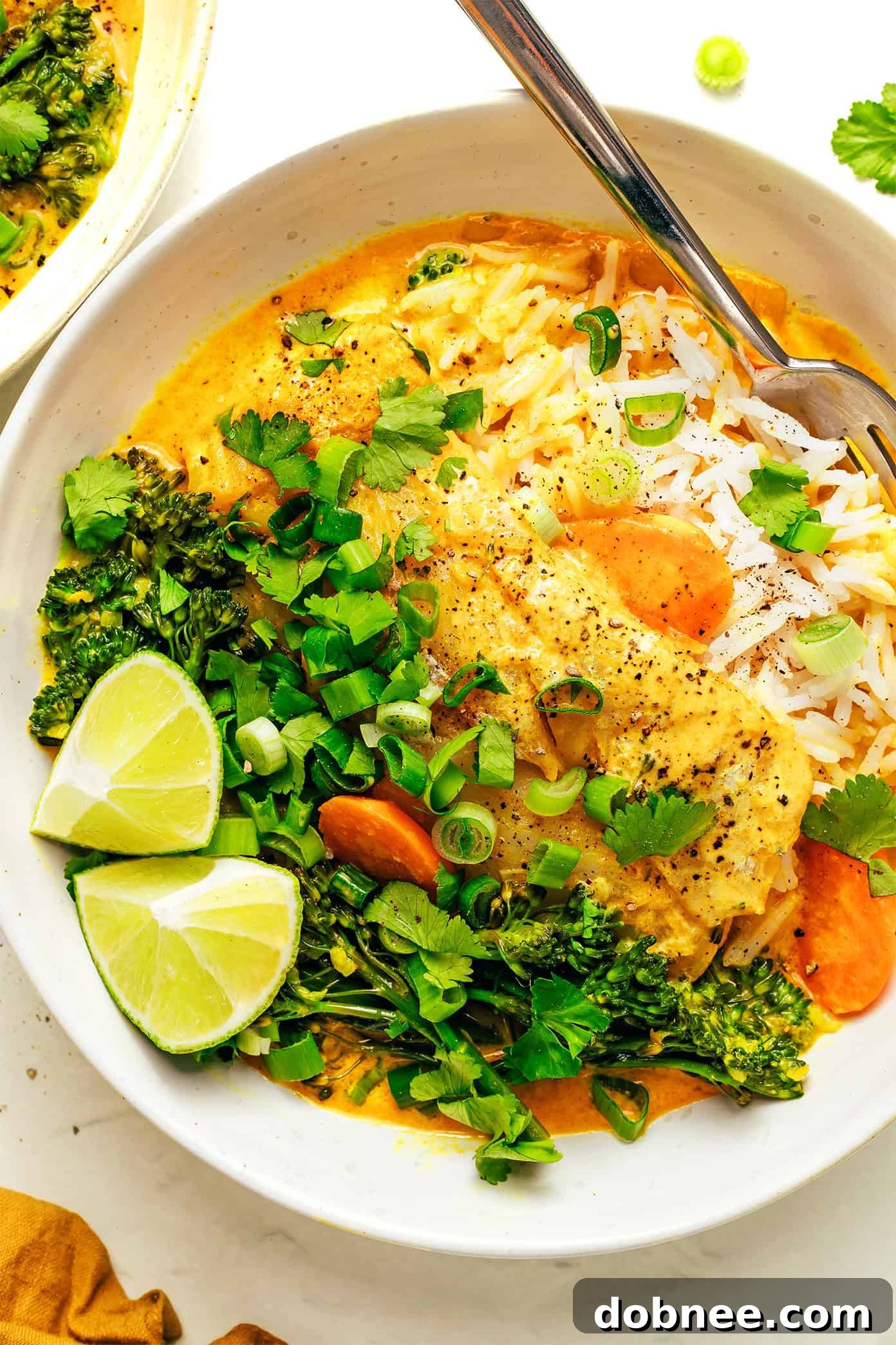 Close-up of a bowl of Thai Fish Curry, showing the creamy texture and fresh ingredients