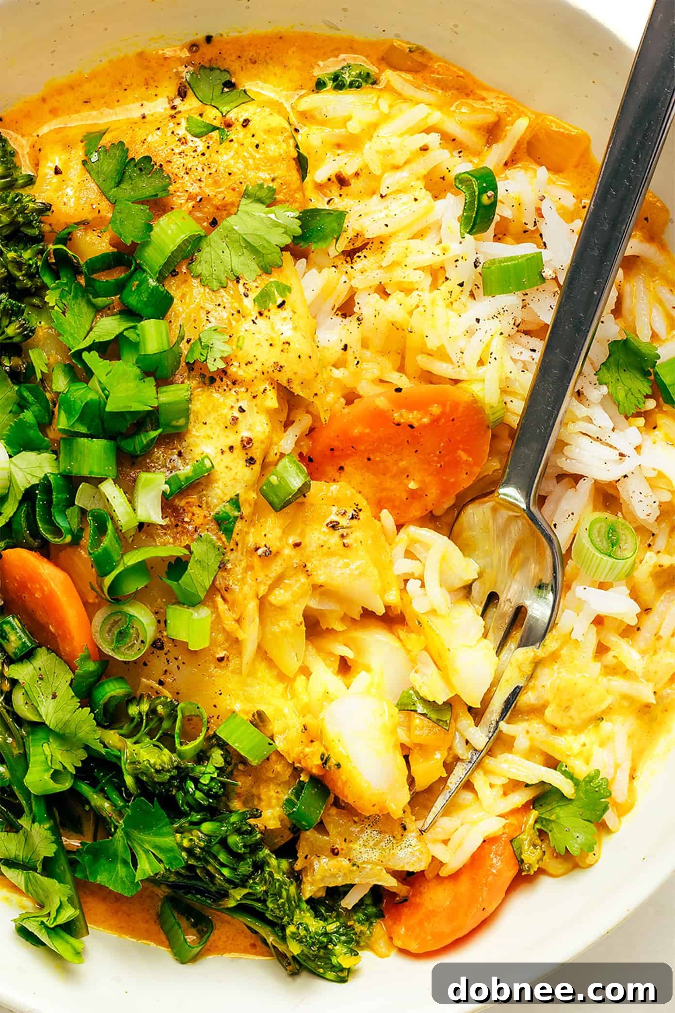 A vibrant and inviting close-up of Thai Fish Curry in a bowl, garnished with fresh herbs