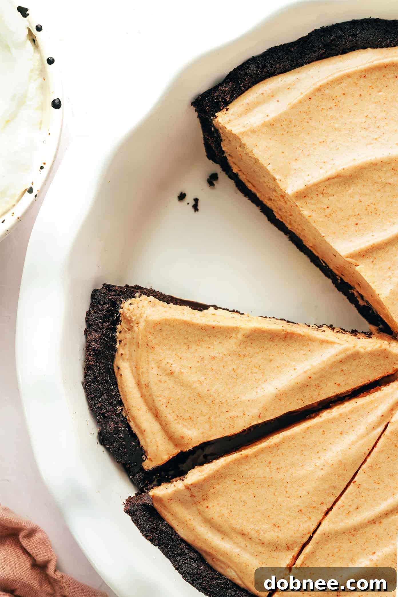 Delicious no-bake peanut butter pie with a rich chocolate Oreo crust and a creamy, fluffy filling, garnished with chocolate shavings.