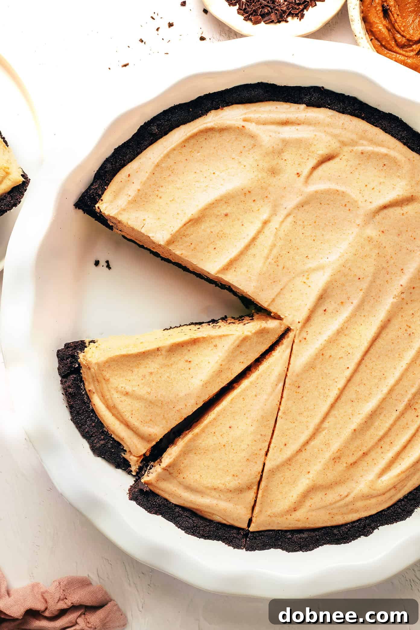 A beautifully presented no-bake peanut butter pie with a chocolate Oreo crust, ready to be served, showcasing its creamy texture and rich color.