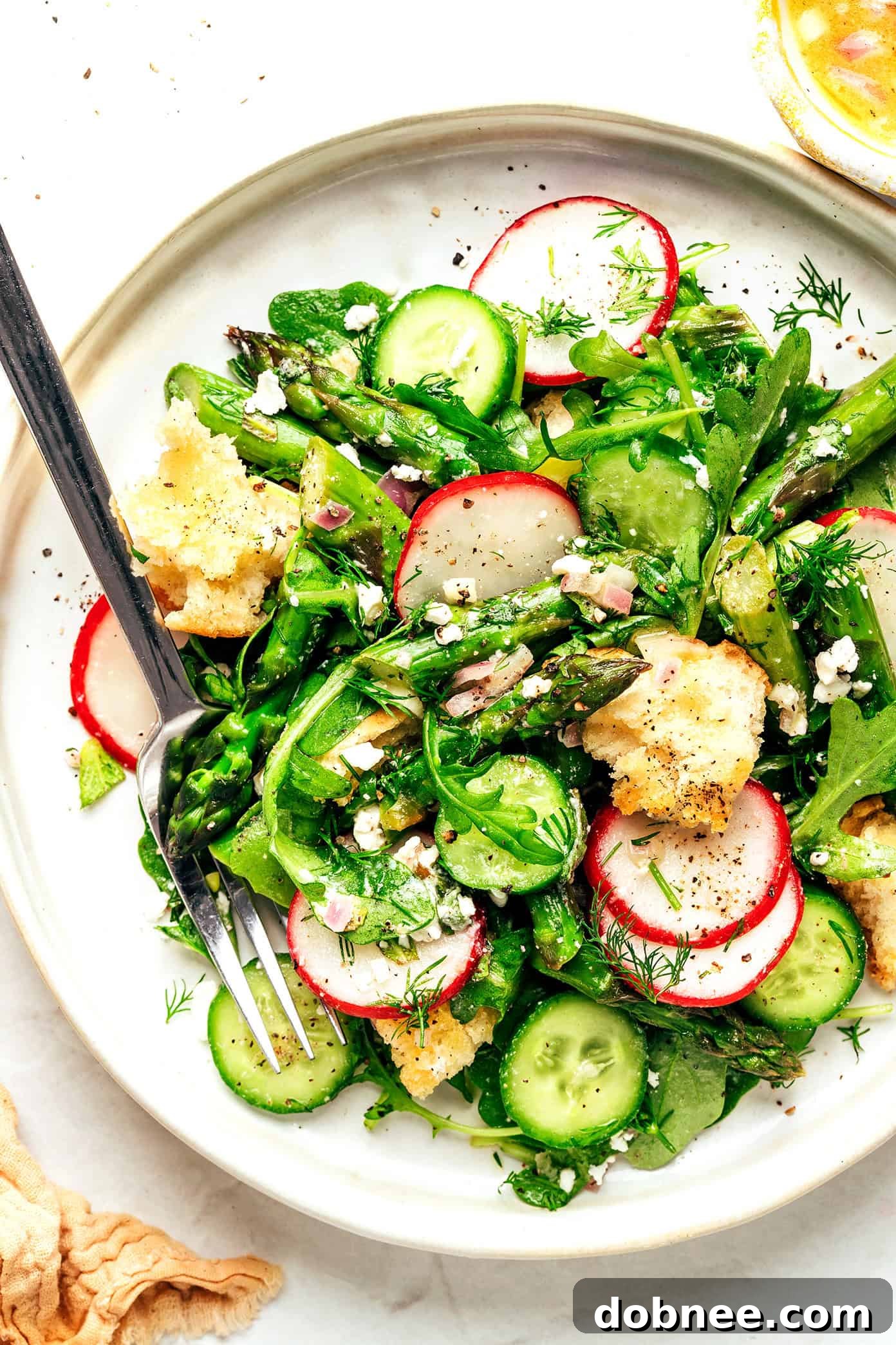 This vibrant spring panzanella salad recipe features crispy sourdough croutons, roasted asparagus, fresh veggies, herbs, feta, and a lemony shallot vinaigrette. | gimmesomeoven.com Spring Panzanella Salad on Plate