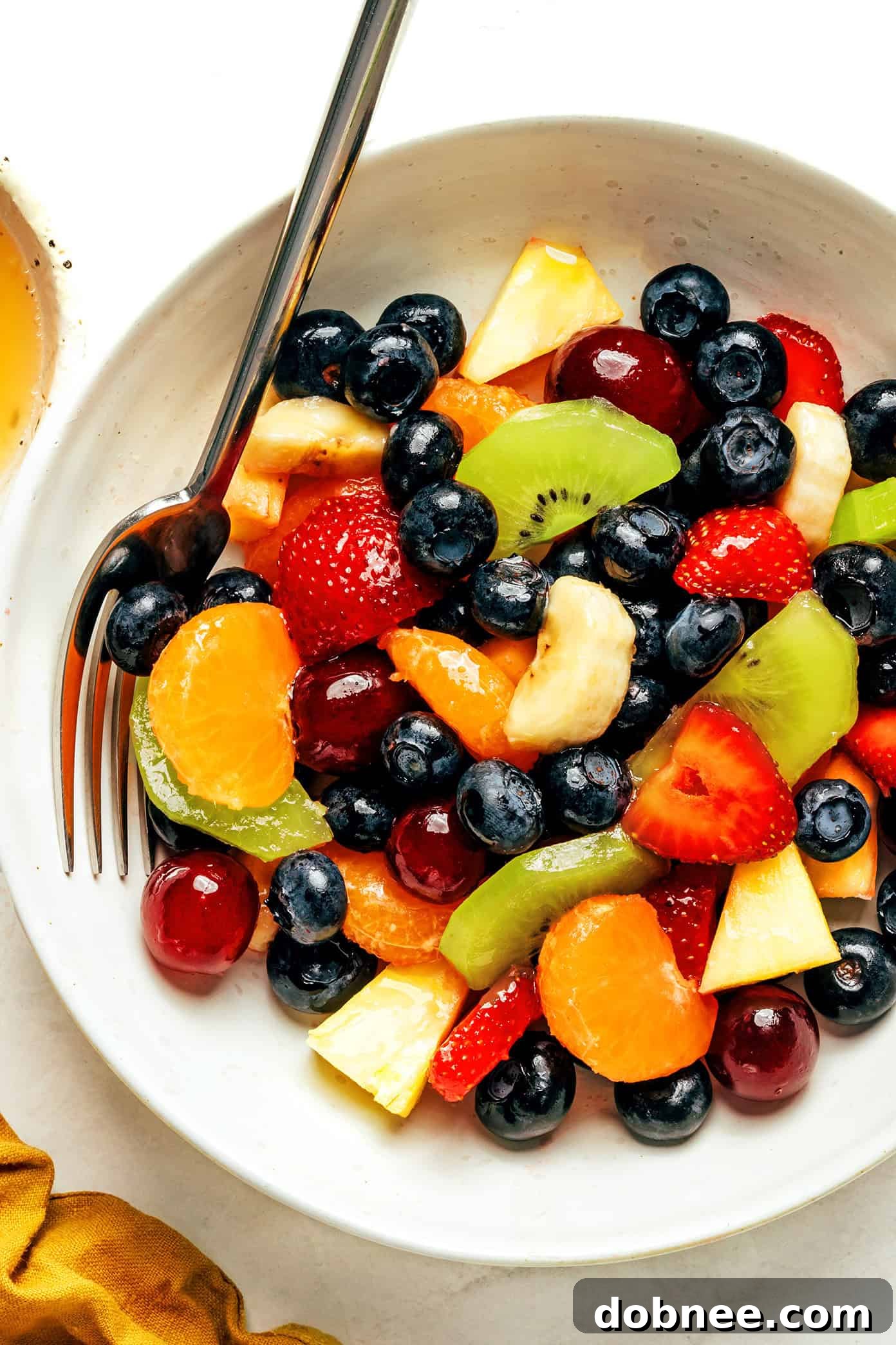 Bowl of vibrant fruit salad with fork