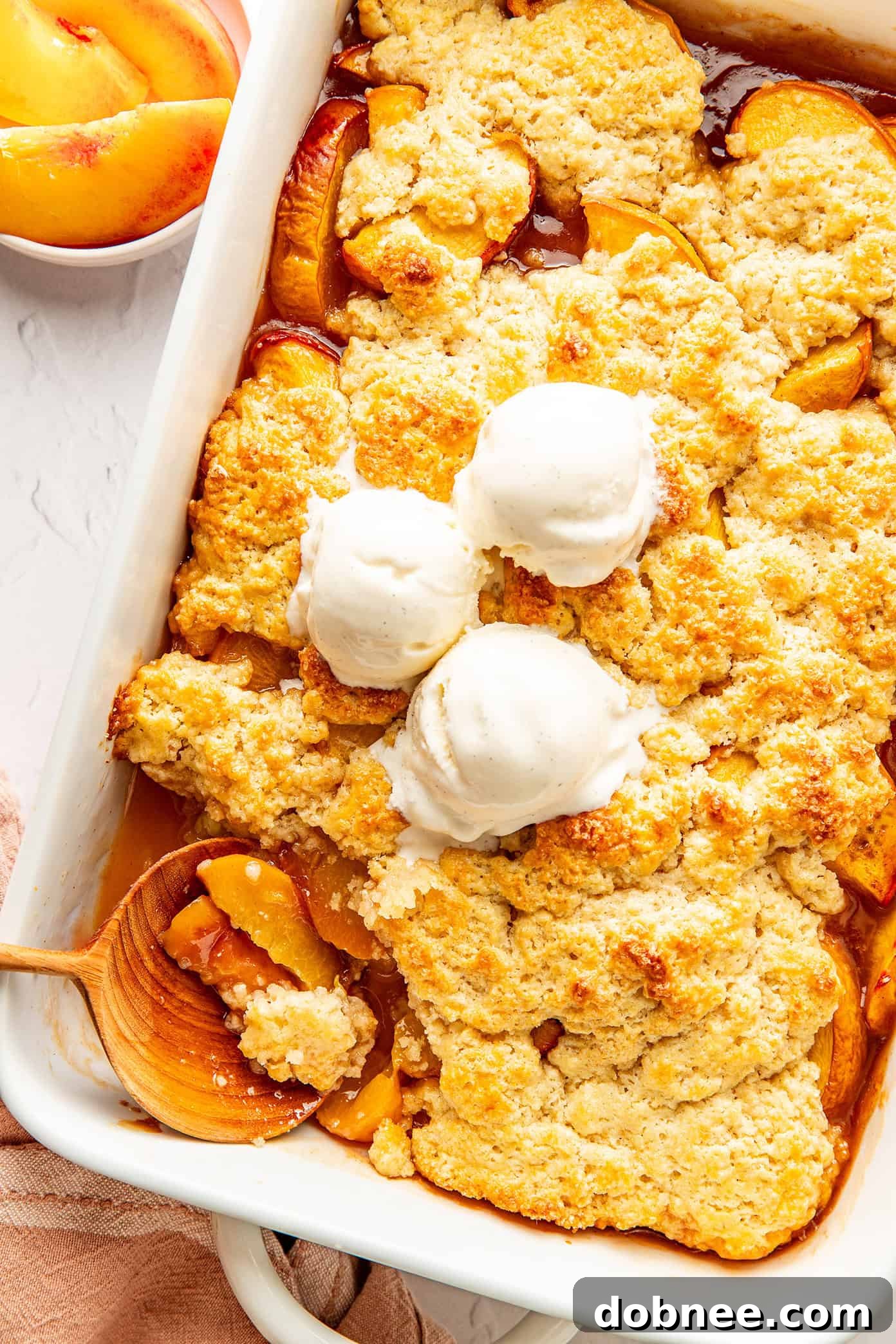 Freshly baked peach cobbler with a golden biscuit topping, ready to be served.