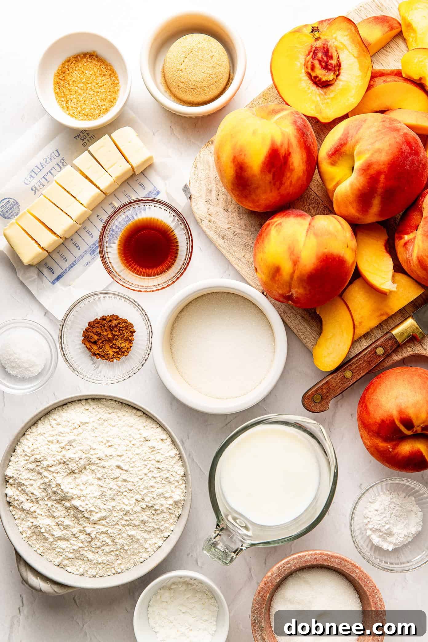 Close-up of fresh peach cobbler ingredients, including sliced peaches, flour, and butter.