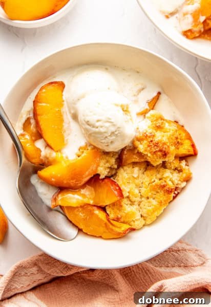A large bowl of perfect peach cobbler with a golden crust.
