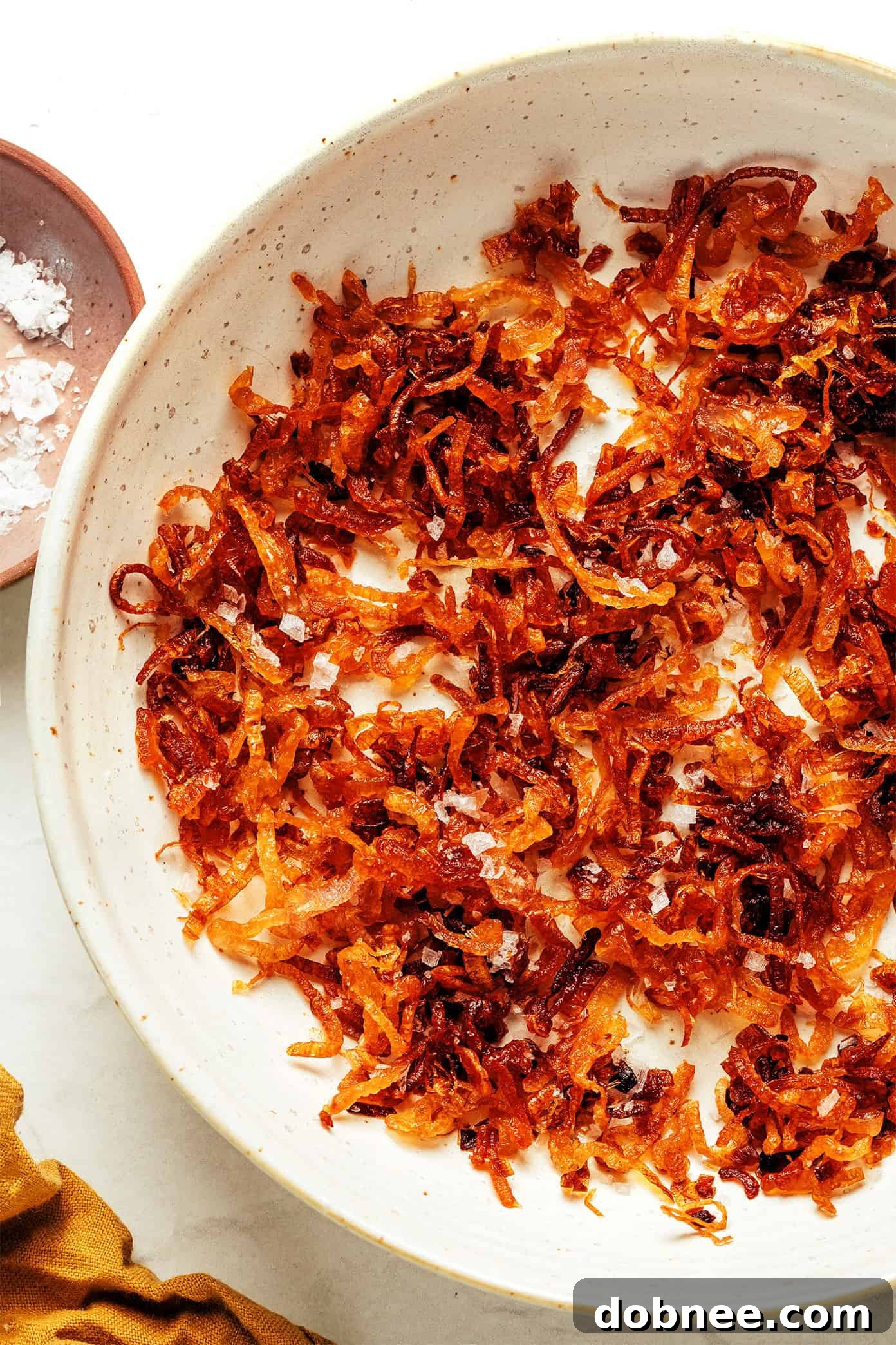 Golden crispy fried shallots in a bowl, ready to be sprinkled on dishes.