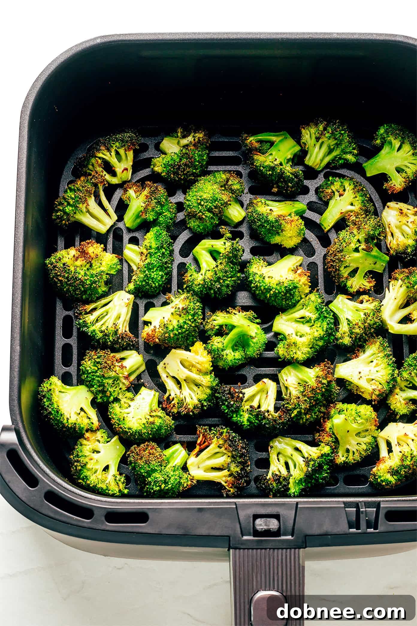 Crispy Air-Fried Broccoli 4 Air fryer basket filled with seasoned broccoli ready for cooking