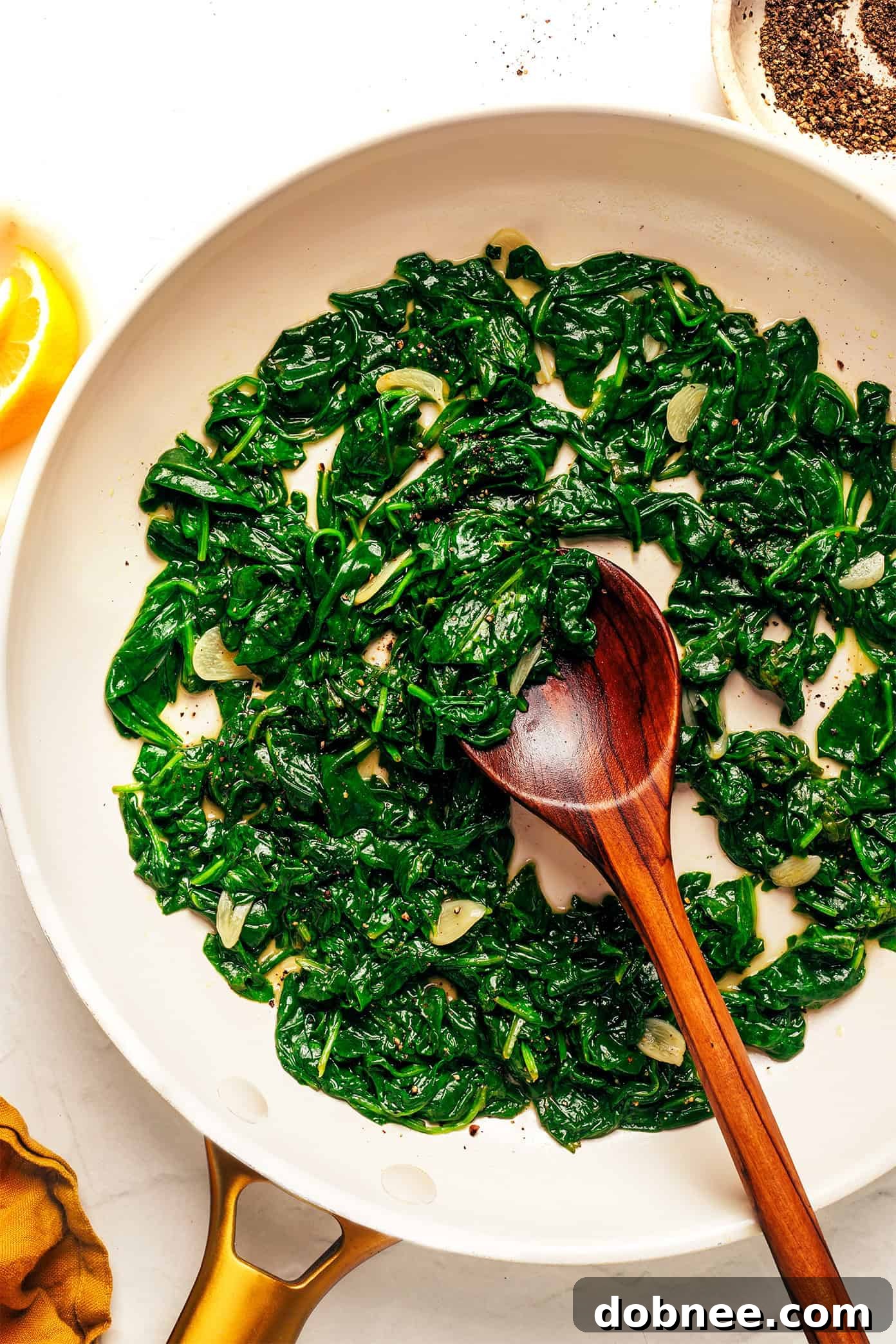 A vibrant bowl of freshly sautéed spinach with garlic and lemon