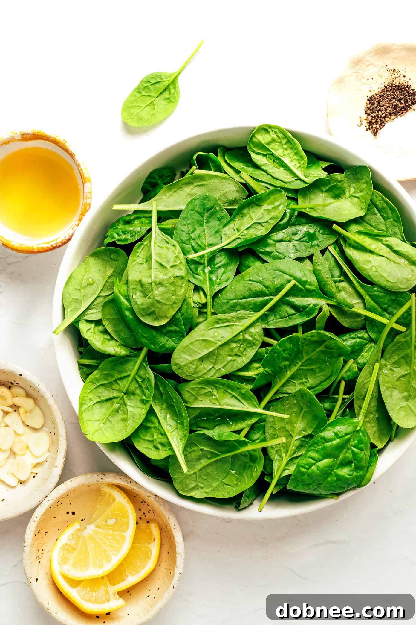 Close-up of garlic cloves and fresh baby spinach leaves before cooking