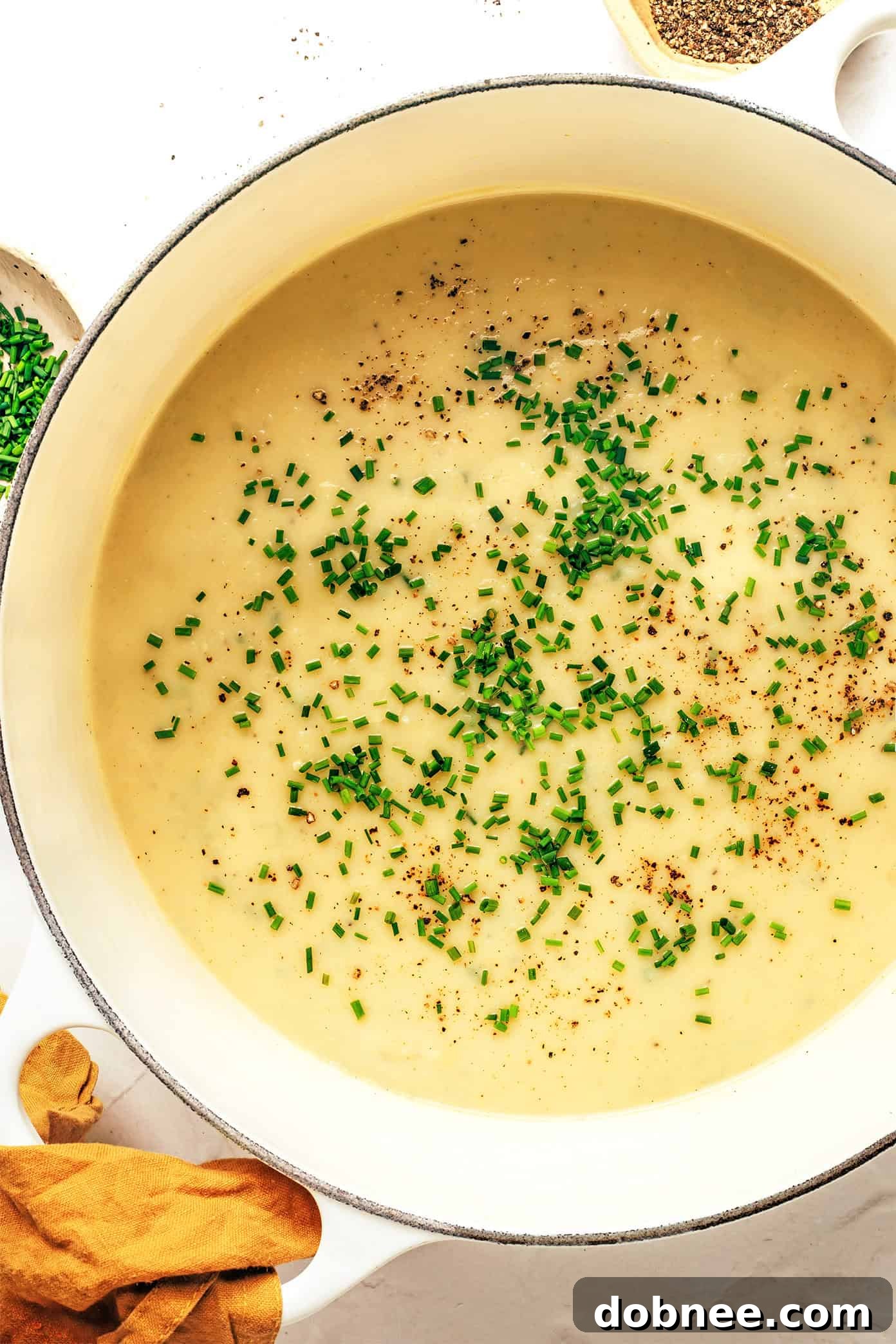 A large pot of creamy potato leek soup simmering on the stove.