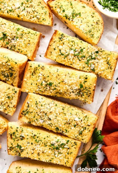 Homemade Garlic Bread on a wooden cutting board.