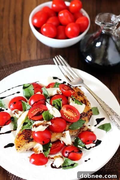 Chicken Caprese | Fresh & Healthy Recipe Close-up of grilled Chicken Caprese, showcasing melted mozzarella, juicy tomatoes, and vibrant basil leaves with a rich balsamic drizzle.