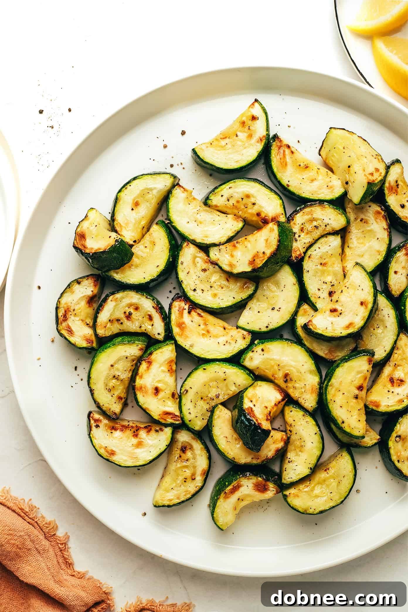 Air Fryer Zucchini slices piled high in a bowl, garnished with fresh herbs