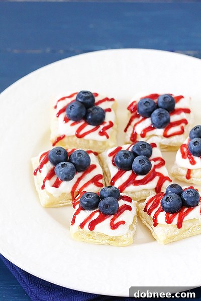 Delicious Berry Cream Cheese Pastry Bites, golden-brown and glistening, arranged artfully on a serving dish.