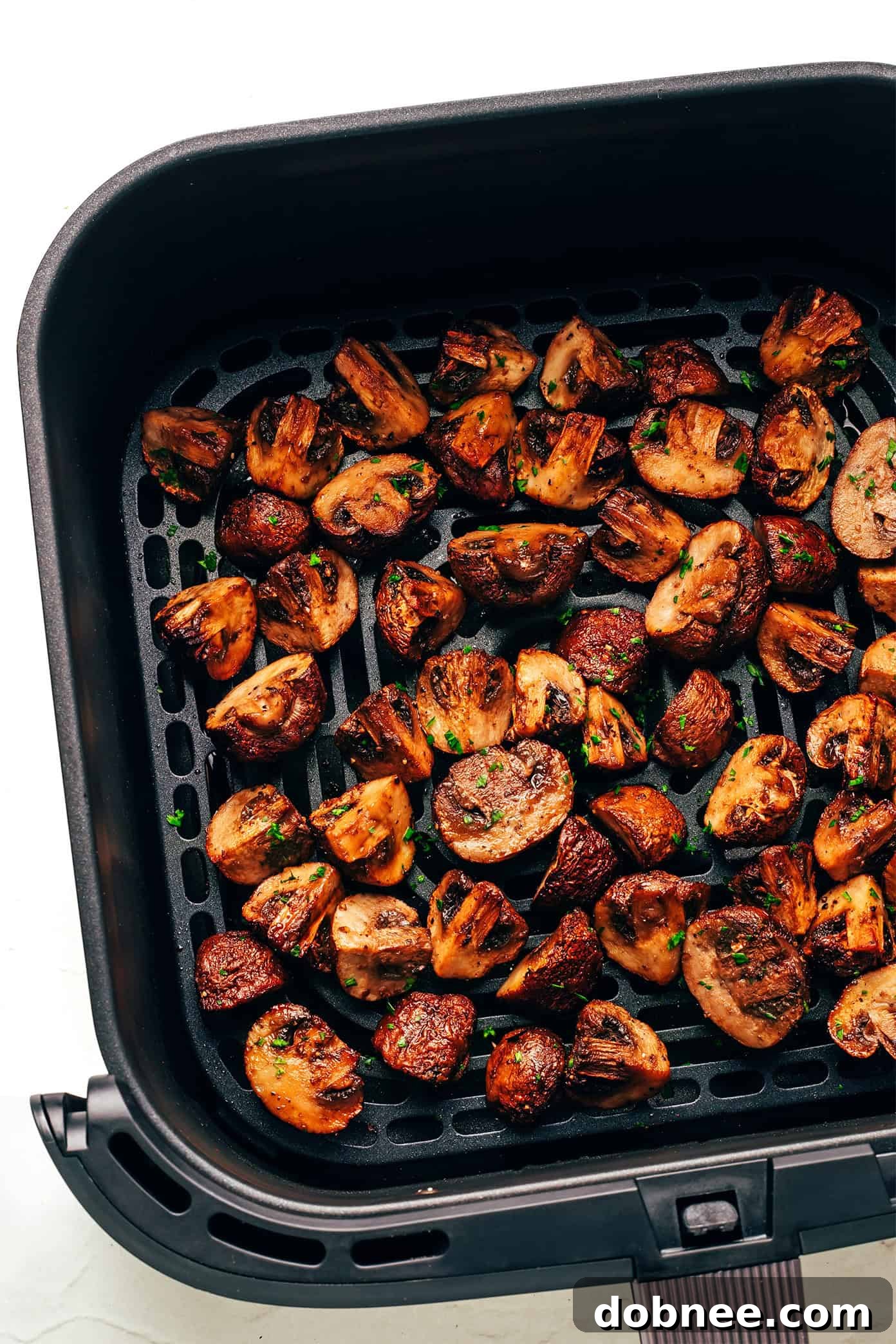 Air-fried mushrooms seasoned and ready to eat, shown with cutlery.