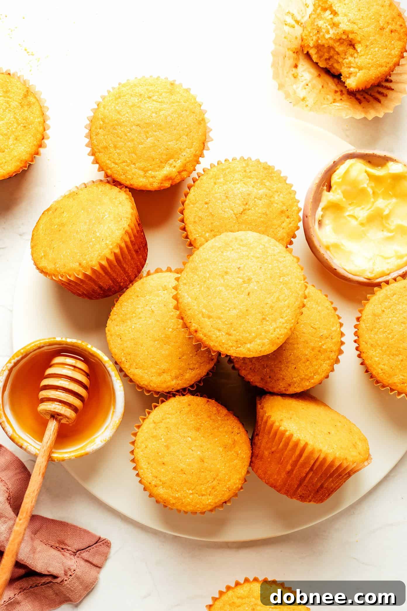 Warm cornbread muffins topped with a dollop of honey butter, ready to serve.